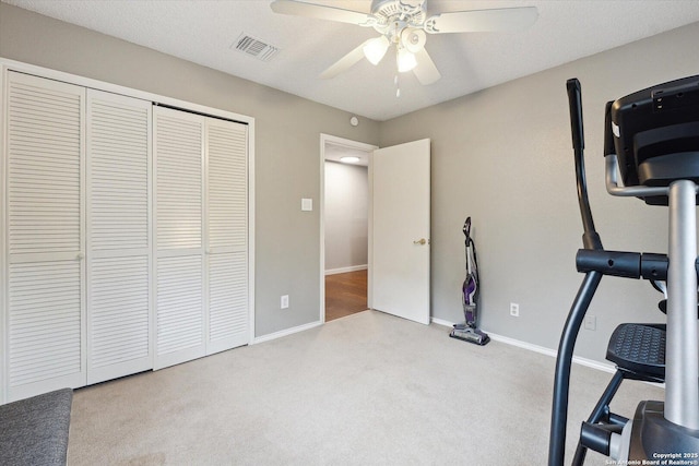 exercise room with light colored carpet and ceiling fan