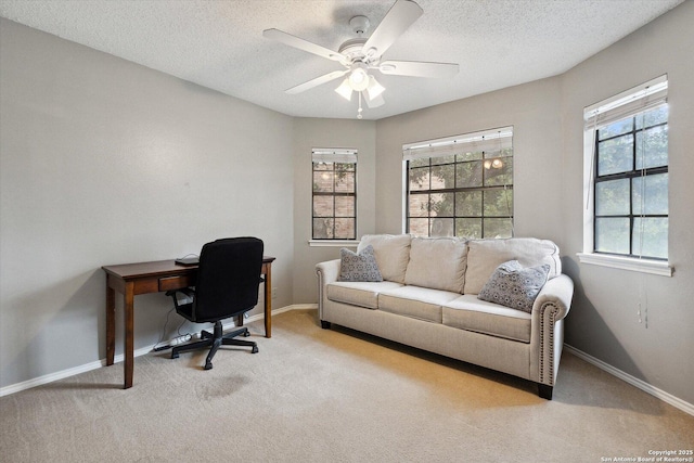 carpeted home office featuring ceiling fan and a textured ceiling