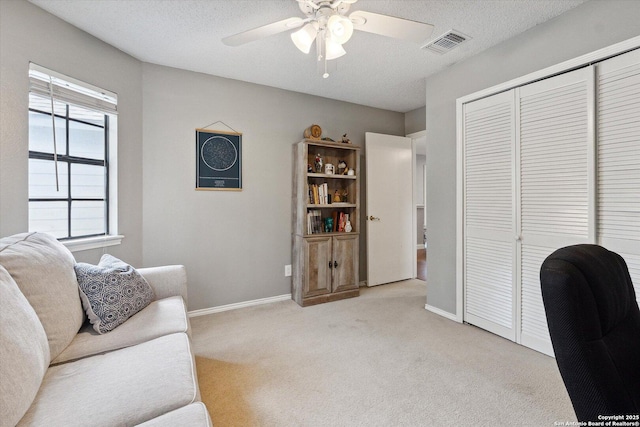 office space with ceiling fan, light colored carpet, and a textured ceiling