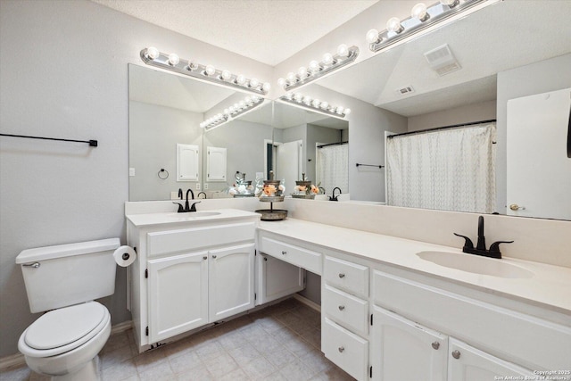 bathroom featuring vanity, a textured ceiling, and toilet