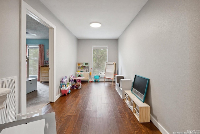 recreation room with dark wood-type flooring