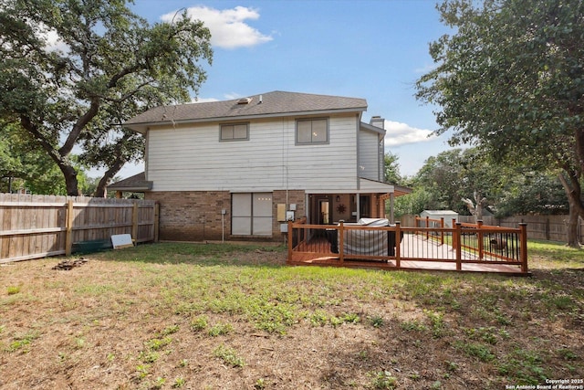 rear view of property featuring a yard and a deck