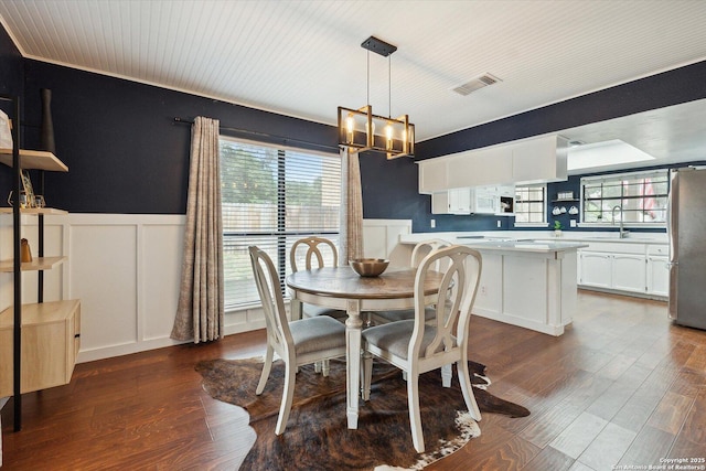 dining room featuring sink, dark hardwood / wood-style floors, and a chandelier