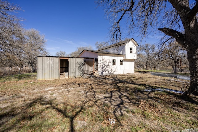 rear view of house featuring an outdoor structure