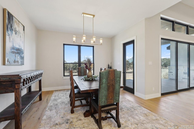 dining space with a chandelier and light wood-type flooring