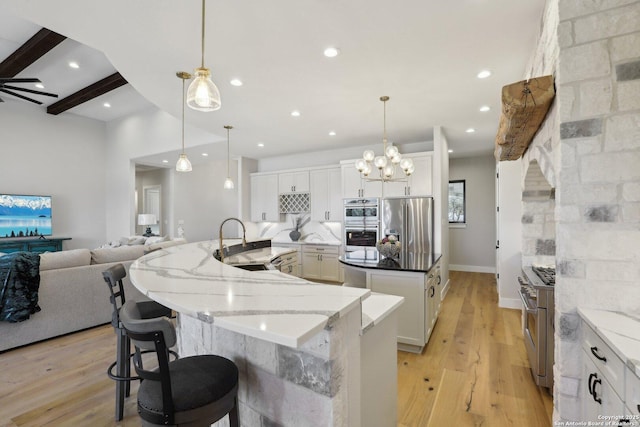 kitchen featuring stainless steel appliances, hanging light fixtures, and white cabinets