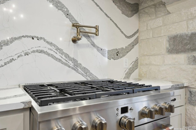 interior details featuring tasteful backsplash and stainless steel range with gas stovetop