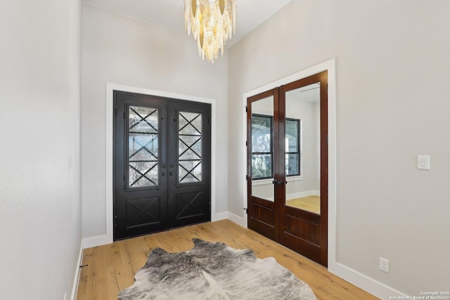 entrance foyer featuring french doors, plenty of natural light, and hardwood / wood-style flooring