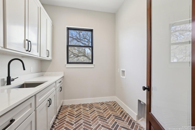 laundry room with sink, hookup for a washing machine, and cabinets