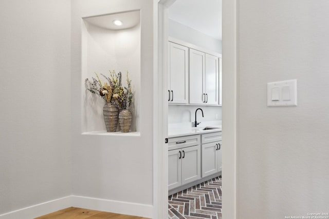 bar featuring sink and white cabinets