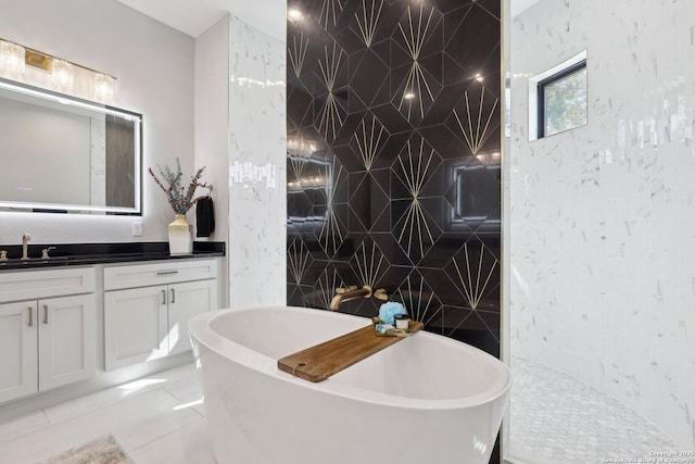 bathroom featuring tile patterned flooring, vanity, and a tub