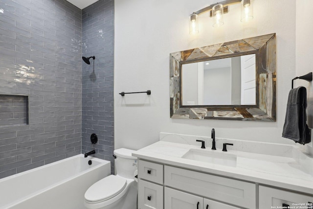 full bathroom featuring tiled shower / bath, vanity, and toilet