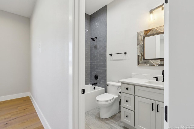 full bathroom featuring tiled shower / bath combo, vanity, wood-type flooring, and toilet