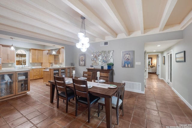 dining room with beamed ceiling and sink