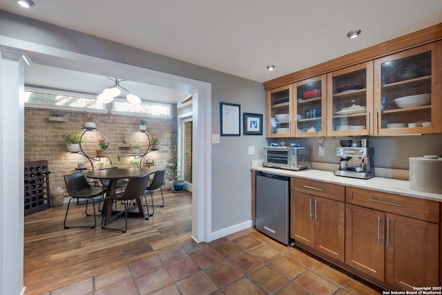 kitchen featuring brick wall, dark tile patterned flooring, and refrigerator