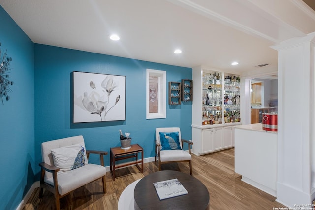 living area featuring light hardwood / wood-style floors and decorative columns