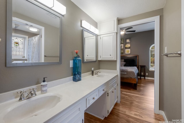 bathroom with ceiling fan, vanity, hardwood / wood-style floors, and a wealth of natural light