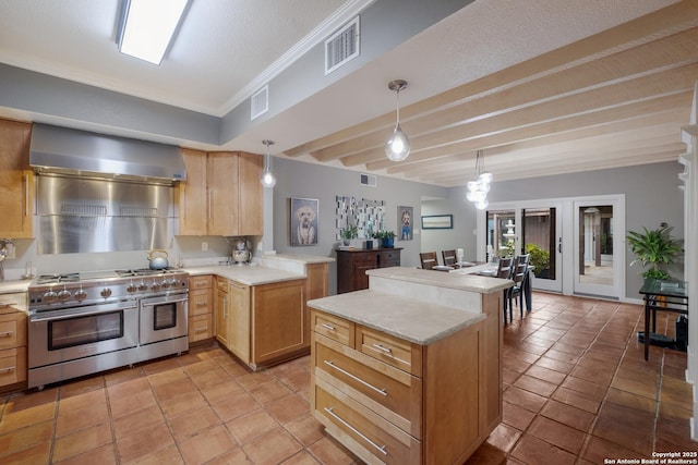 kitchen with crown molding, double oven range, kitchen peninsula, pendant lighting, and wall chimney range hood