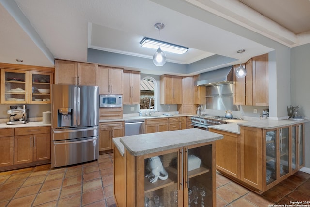 kitchen featuring wall chimney exhaust hood, sink, hanging light fixtures, appliances with stainless steel finishes, and kitchen peninsula