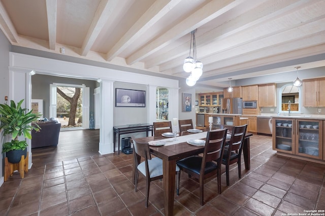 dining room with beamed ceiling and sink