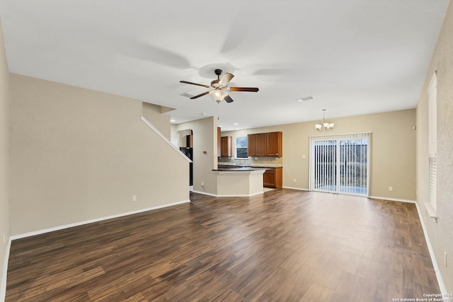 unfurnished living room featuring dark hardwood / wood-style floors and ceiling fan with notable chandelier