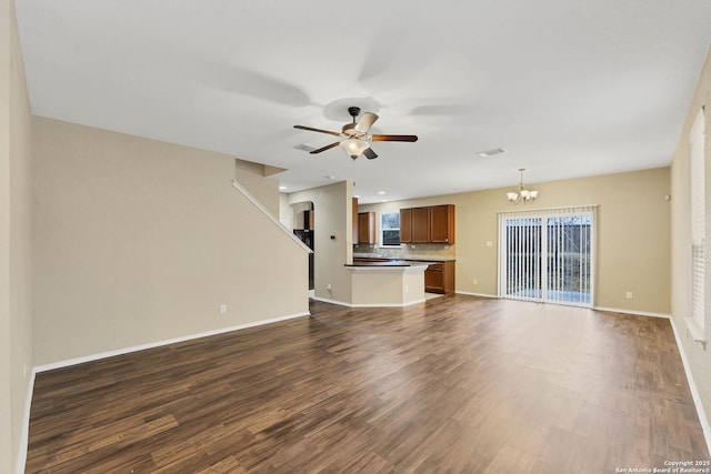 unfurnished living room with dark hardwood / wood-style flooring and ceiling fan with notable chandelier