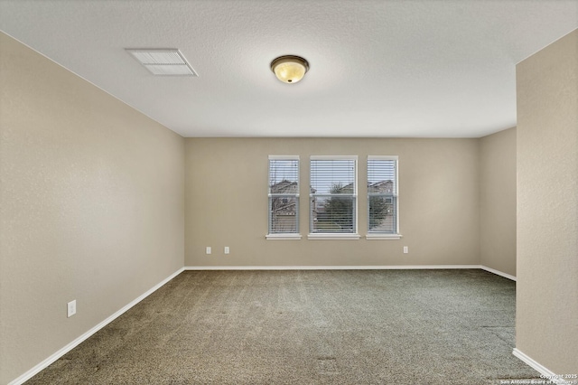 carpeted spare room featuring a textured ceiling