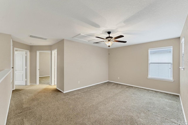 carpeted spare room with ceiling fan and a textured ceiling