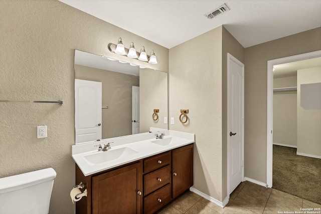 bathroom featuring tile patterned flooring, vanity, and toilet