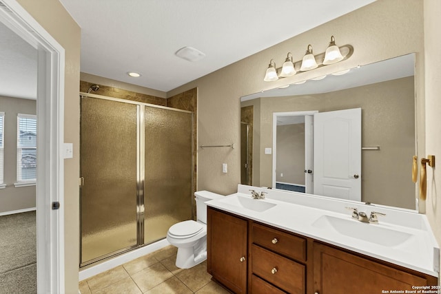 bathroom with a shower with door, vanity, tile patterned flooring, and toilet