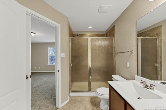 bathroom featuring vanity, a shower with door, tile patterned floors, and toilet