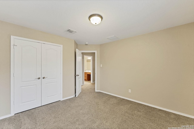 unfurnished bedroom featuring light colored carpet and a closet