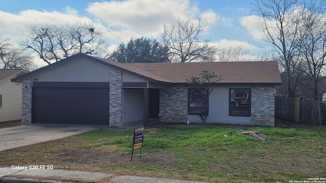 view of front of property featuring brick siding, concrete driveway, an attached garage, a front yard, and fence