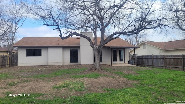 back of house featuring a yard and french doors