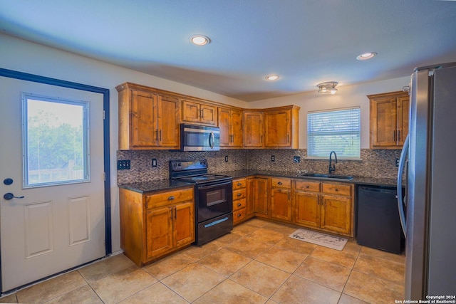 kitchen with tasteful backsplash, light tile patterned flooring, sink, and black appliances