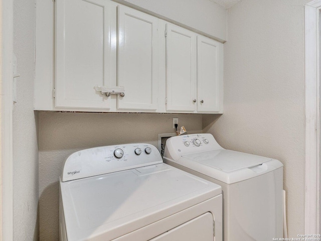 washroom featuring cabinets and washing machine and dryer