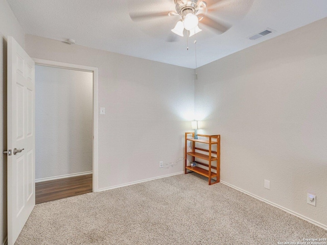 spare room featuring ceiling fan and carpet floors