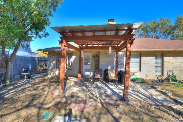 rear view of house featuring a pergola and a patio area