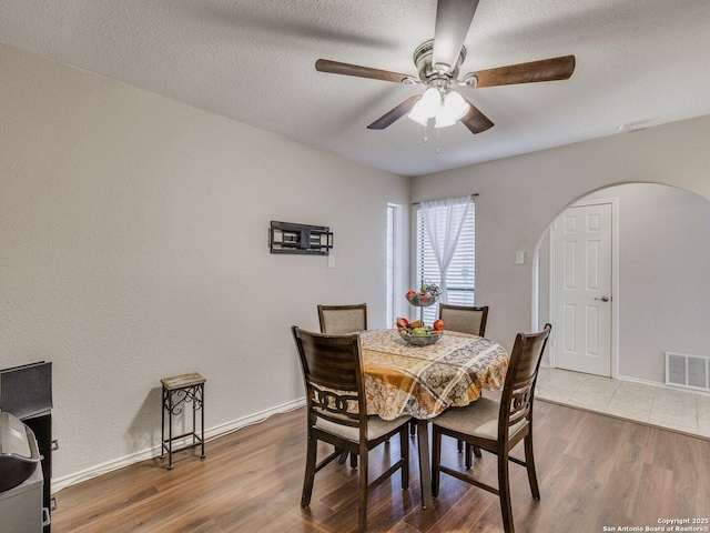 dining area featuring ceiling fan, hardwood / wood-style floors, and a textured ceiling