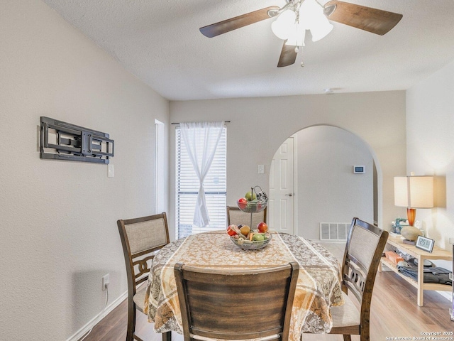 dining room with hardwood / wood-style flooring, a textured ceiling, and ceiling fan