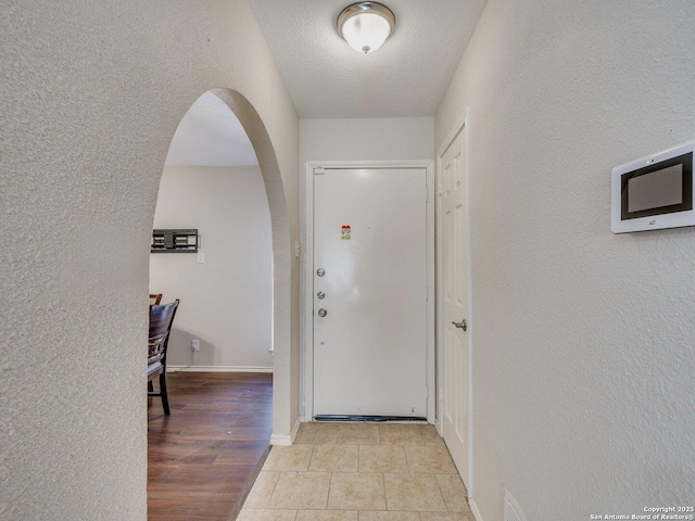 tiled entryway featuring a textured ceiling