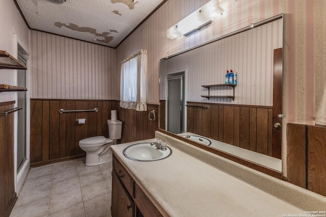 bathroom featuring crown molding, vanity, a textured ceiling, tile patterned floors, and toilet