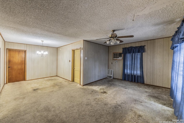 carpeted spare room with a wall unit AC, ceiling fan with notable chandelier, and a textured ceiling