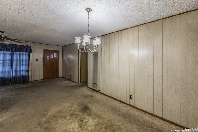 unfurnished dining area with ceiling fan with notable chandelier, a textured ceiling, and carpet