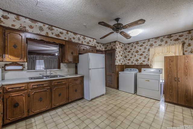 kitchen with washing machine and dryer, white fridge, sink, and a textured ceiling