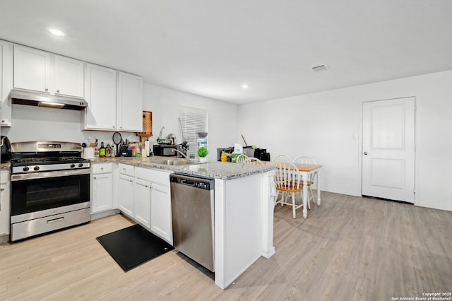 kitchen featuring sink, white cabinetry, light hardwood / wood-style flooring, appliances with stainless steel finishes, and kitchen peninsula