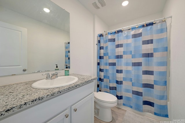 bathroom with vanity, walk in shower, and toilet