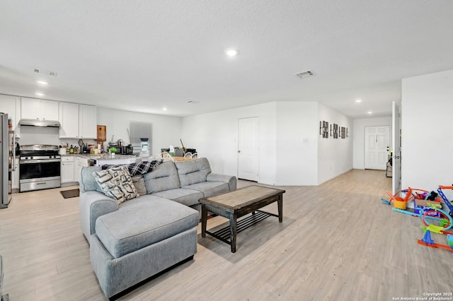 living room featuring light hardwood / wood-style flooring and a textured ceiling