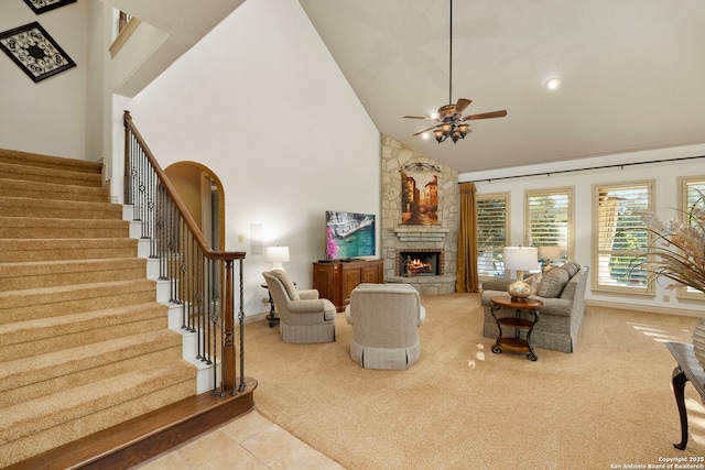 carpeted living room featuring ceiling fan, a fireplace, and high vaulted ceiling