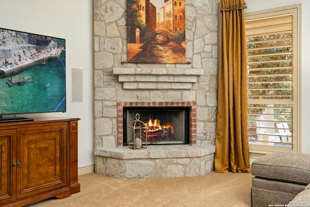 living room with carpet flooring and a stone fireplace